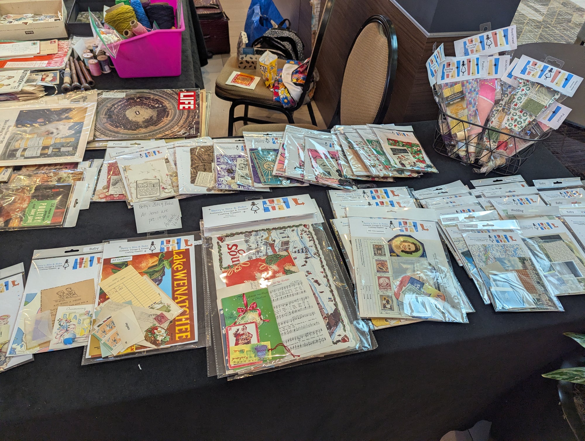Wholesale table display of Betty's Bits & Bobs vintage ephemera packs and craft materials.